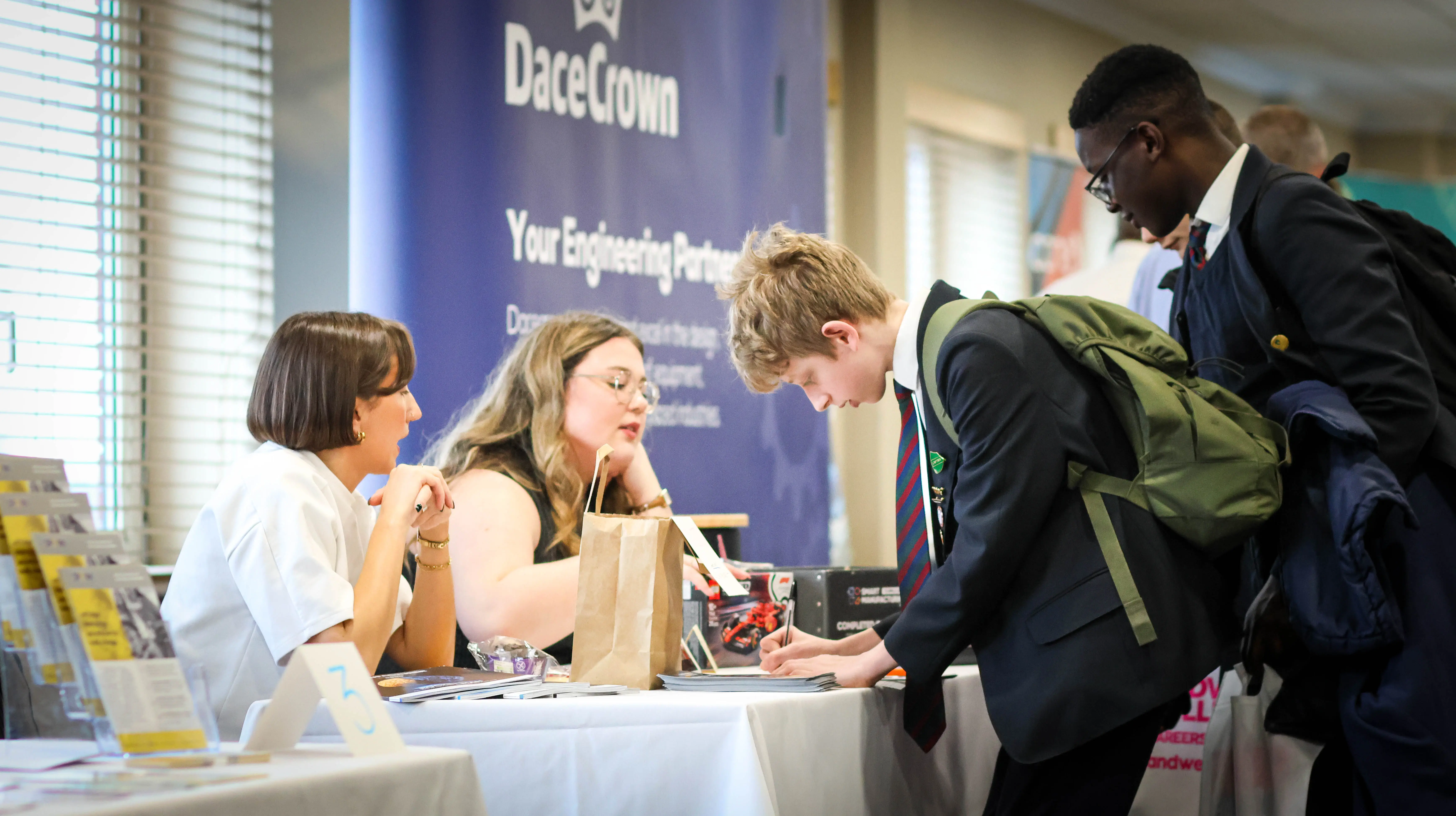 Students talking to staff at an exhibition stand