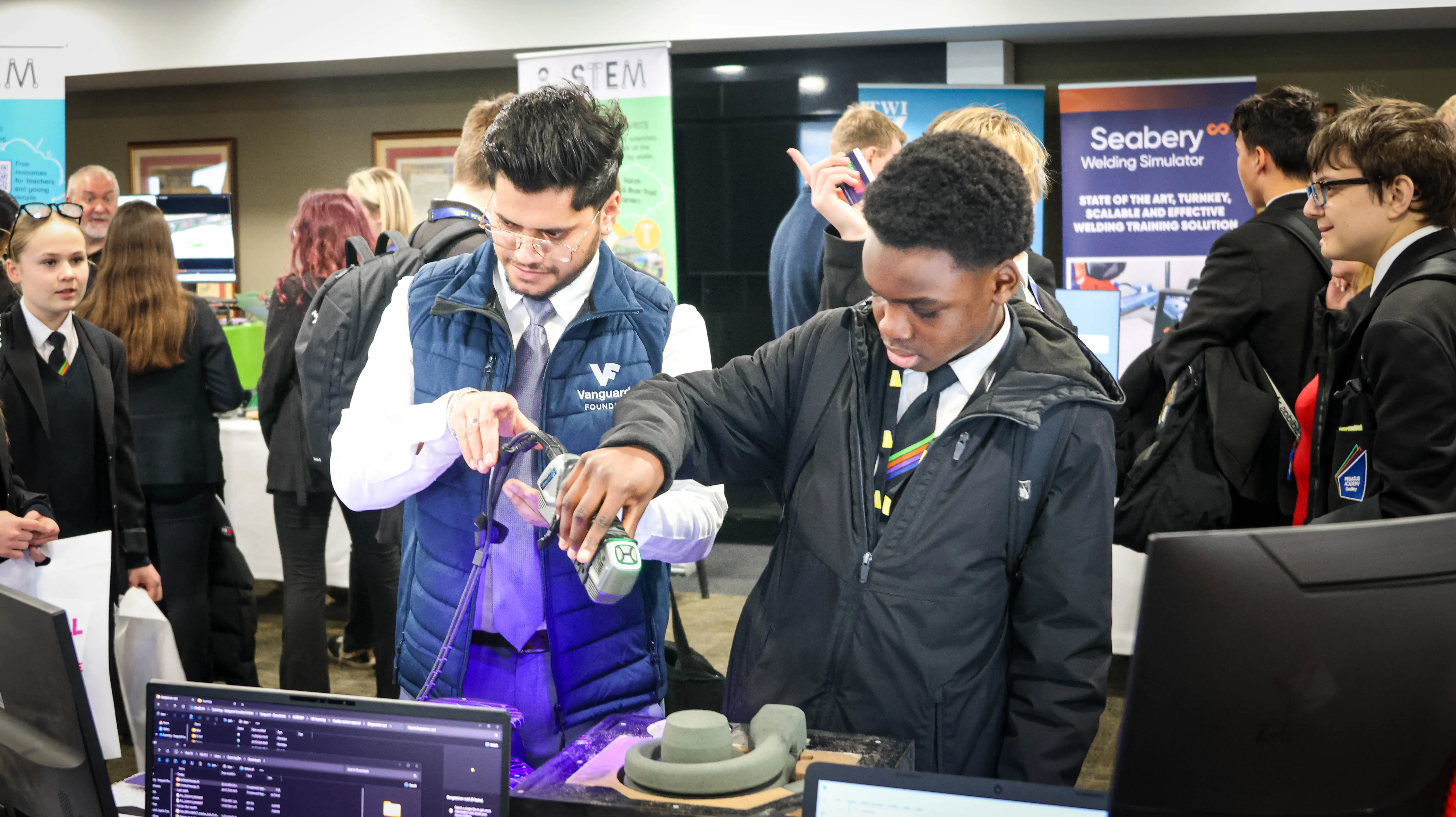 Exhibitor showing student how to use machine